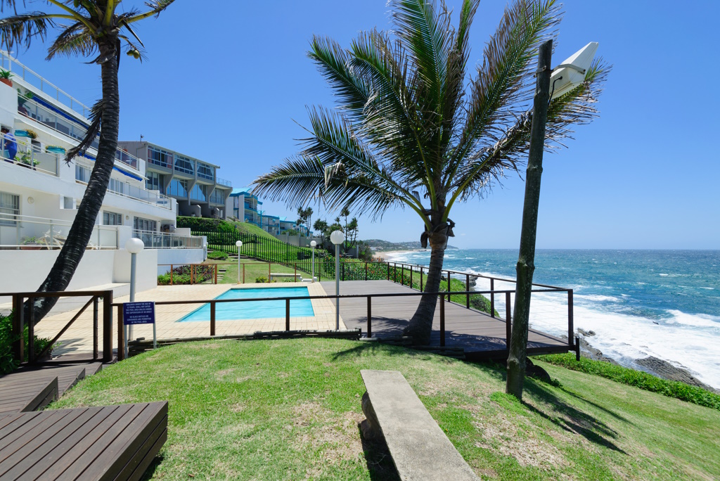 Palm trees over a pool deck looking onto the Indian Ocean at Ballito