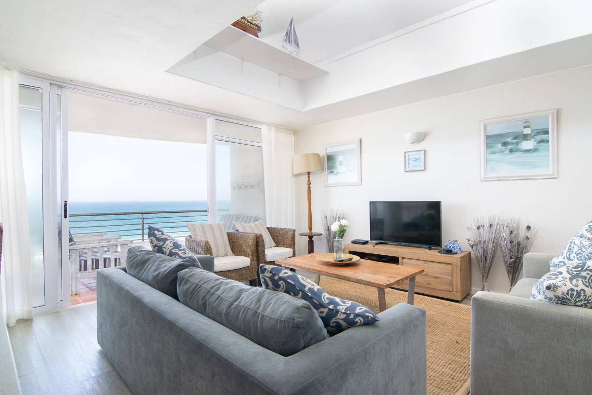 Light-filled lounge opening onto a sea-view balcony