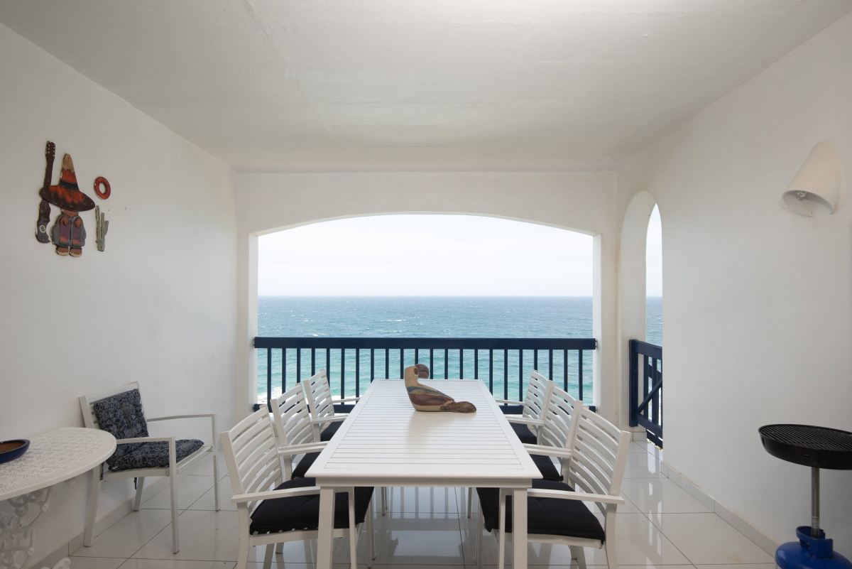 Arched penthouse balcony with a dining table facing the Indian Ocean