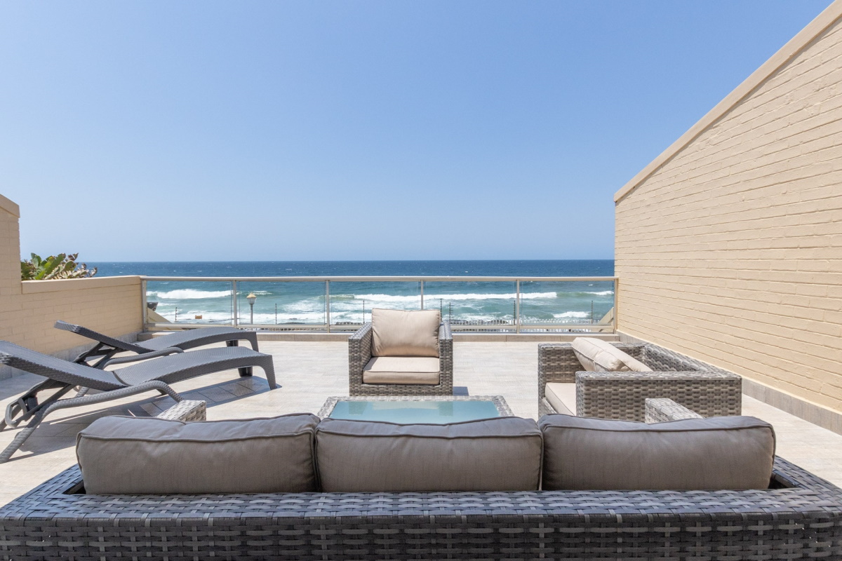 Private rooftop terrace with sun loungers above the surf